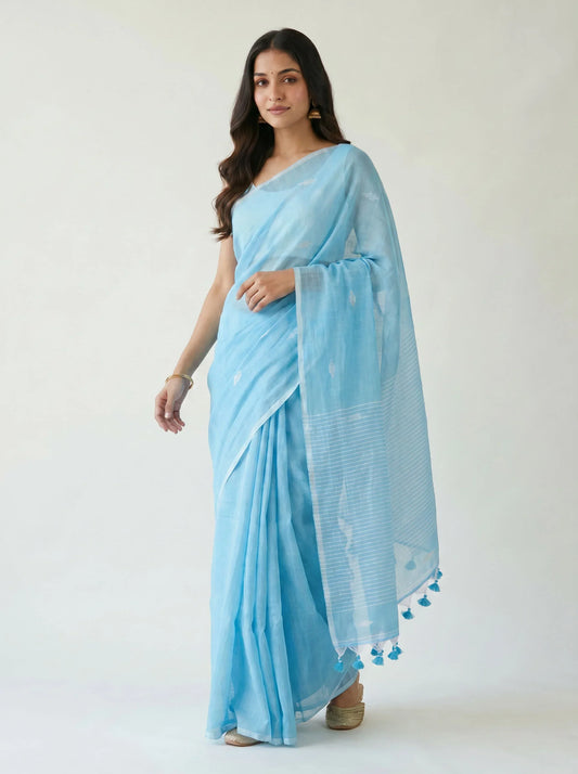 Woman wearing a light blue saree with a white background
