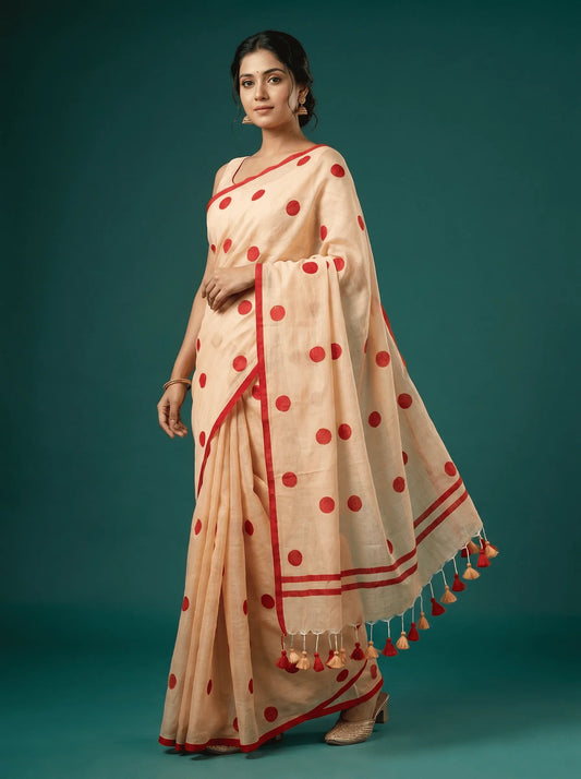 Beige saree with red polka dots and tassels, elegant traditional wear for women
