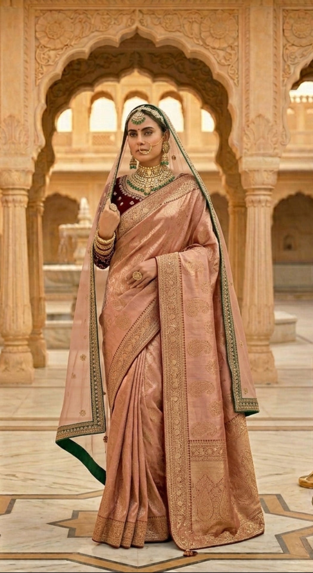 Woman in traditional pink saree with gold details in a grand architectural setting