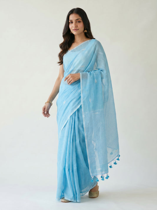 Woman wearing a light blue saree with a white background